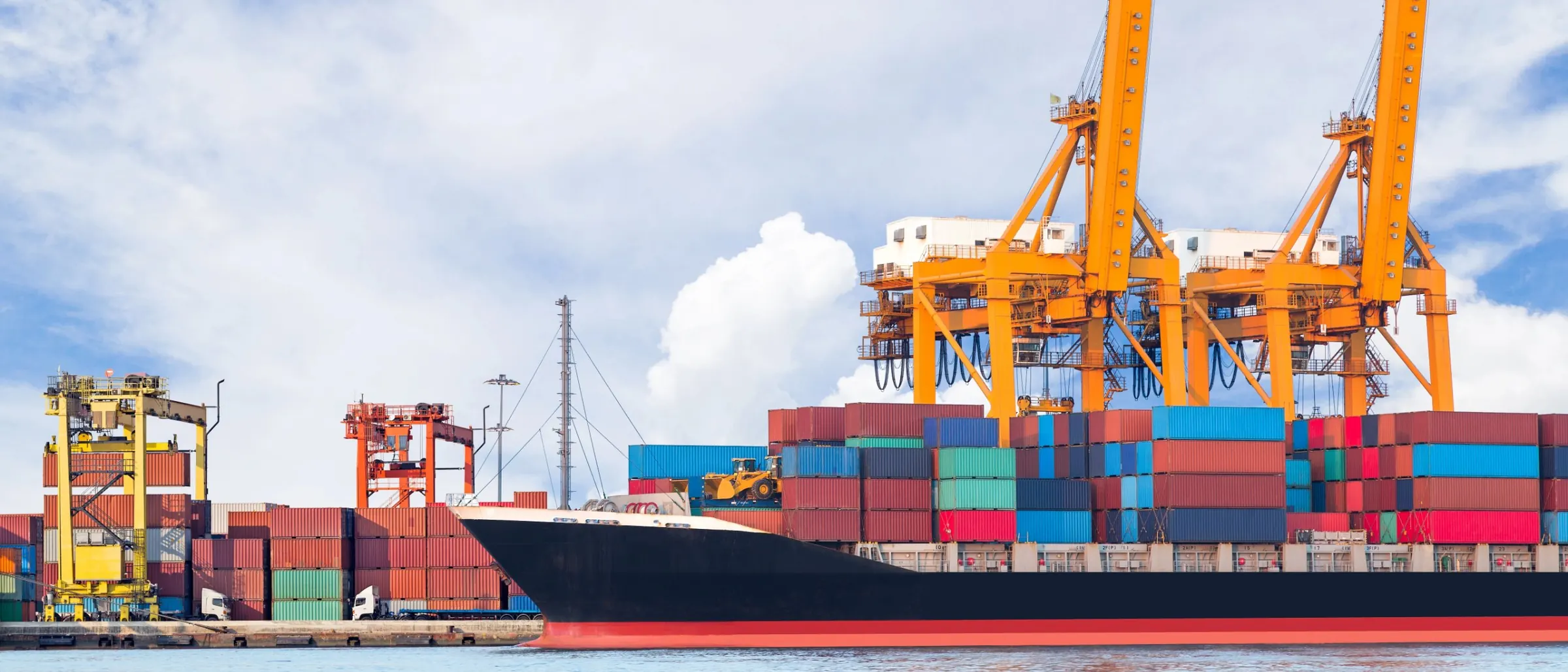 Shipping containers being loaded onto a cargo ship at a port